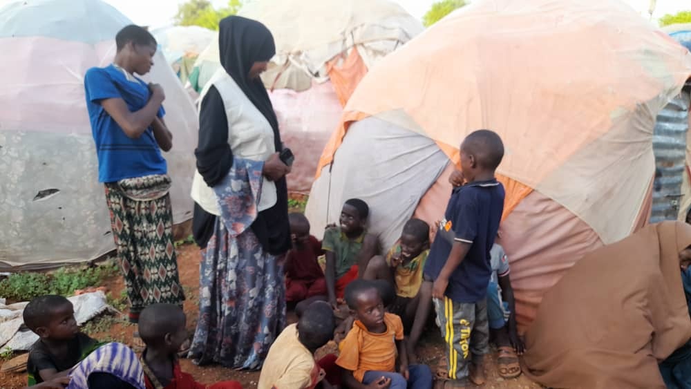 Displaced families gathered outside makeshift shelters